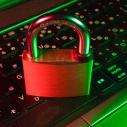 A lock is on top of a keyboard, representing cybersecurity.